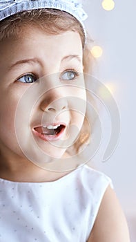 Happy amazed female kid emotion. Suprised child studio portrait. Young girl