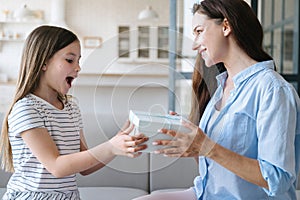 Happy amazement girl receive box with gift from mother