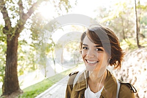 Happy amazing woman walking outdoors in park in beautiful spring day