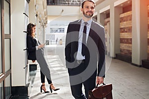 Happy ambitious businessman leaving the office building