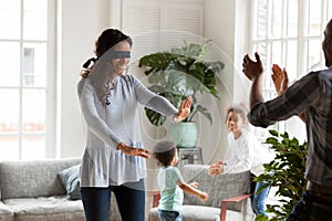 Happy American black family playing hide and seek at home