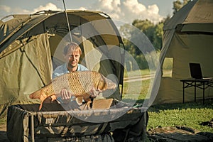 Happy angler with carp fishing trophy