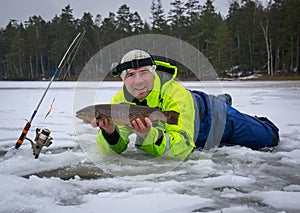 Happy angler fishing on the ice