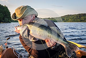 Happy angler kissing walleye fishing trophy