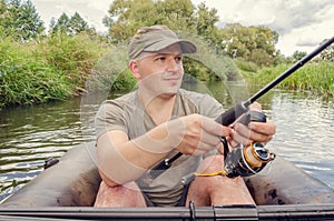 Happy angler sits in a boat on a sunny day