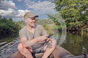 Happy angler sits in a boat on a sunny day