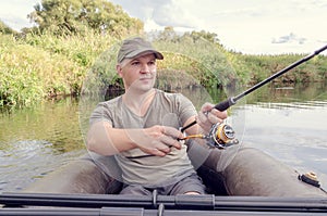 Happy angler sits in a boat on a sunny day