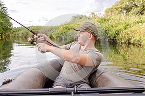 Happy angler sits in a boat on a sunny day