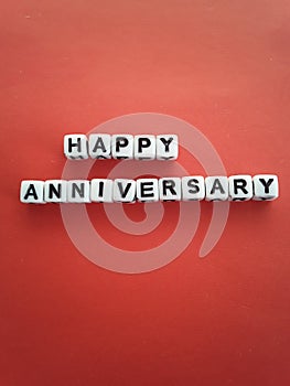 Happy anniversary words letters on white blocks on a red background
