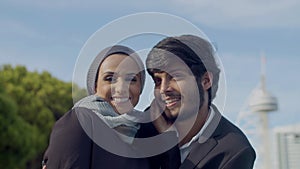 Happy Arab man looking at his beautiful wife with tenderness