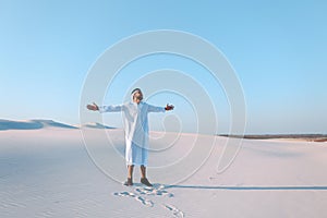 Happy Arab man walks in middle of white desert and enjoys life on hot summer day.