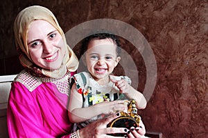 Happy arab muslim mother with her baby girl with ramadan lantern