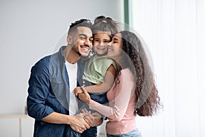 Happy Arab Parents And Their Little Daughter Bonding At Home