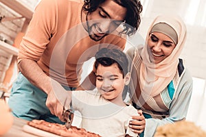 Happy Arabian Family Eating Pizza in Kitchen