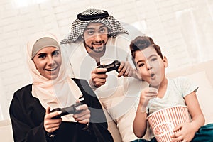 Happy Arabian Family Playing on Console at Home.