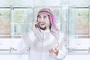 Happy Arabian man speaking on cellphone