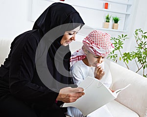 Happy Arabic child at home with his mother photo