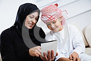 Happy Arabic child at home with his mother photo