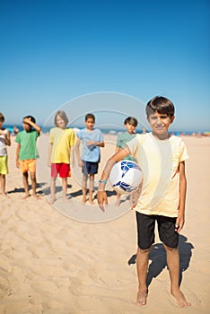 Happy Arabic preteen boy posing with soccer ball