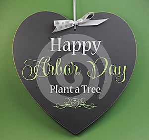 Happy Arbor Day, Plant a Tree, greeting message sign on heart shaped blackboard