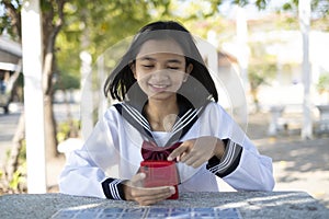 Happy Asain student use smart phone and sitting at school