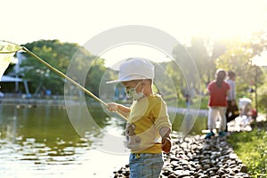 Happy Asia Chinese little boy toddler child play by lake holding string net catch fish carefree childhood parent-child activity