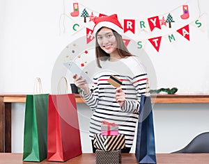 Happy Asia woman use credit card buy Christmas gift with mobile