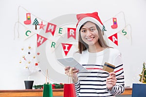 Happy Asia woman use credit card buy Christmas gift with mobile