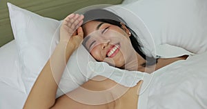 Happy Asia Woman wear white nightwear sleeping in white comfortable cozy bed at home. lady opens her eyes on a sunny morning.