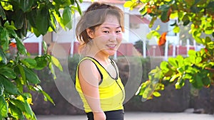 Happy asian armless woman warming up before swimming at the tropical beach