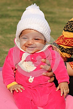 Happy asian baby girl in white winter cap