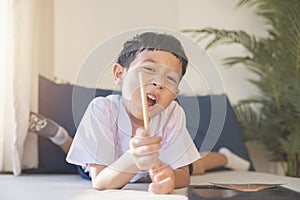 Happy Asian boy 6-7 years old, black hair, white skin, wearing white shirt and blue shorts looking at camera. Children in school