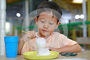 Happy Asian boy painting a doll with watercolor. Kid with water color painting activity