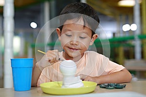 Happy Asian boy painting a doll with watercolor. Kid with water color painting activity