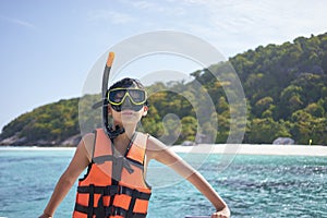 Happy Asian boy wearing snorkel and preparing for swimming in Phuket, Thailand photo