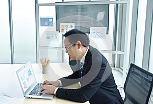 Happy Asian business man using computer laptop in office room