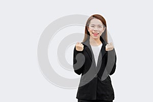 Happy asian business woman arms up in black suit isolated on white color background