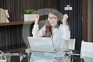 Happy Asian business woman finishing works in office