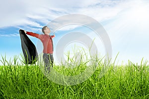 Happy asian businessman with open arms holding a suit standing on the grass