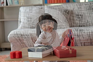 Happy Asian child with arms up holding shopping bags, Christmas and New Year kid concept