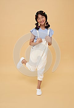 Happy Asian child attractive pretty celebrating great success and walking isolated on color copy space background