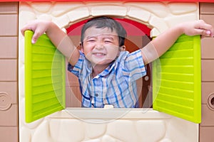 Happy Asian child Boy playing with window toy house