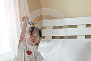 Happy Asian child enjoy playing with toy airplane in hands