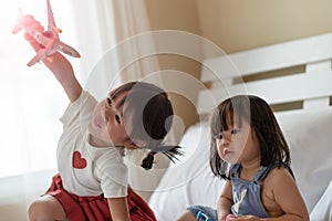 Happy Asian child enjoy playing with toy airplane in hands