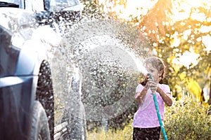 Happy asian child girl help parent washing car