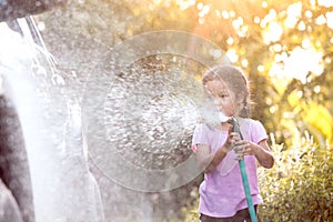 Happy asian child girl help parent washing car