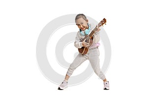 Happy Asian child girl play ukulele, isolate on white