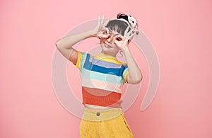 Happy Asian child girl showing hand ok gesture  on pink background
