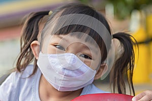 Happy Asian child girl smiling and wearing fabric mask