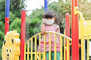 Happy Asian child girl smiling and wearing face mask,Ã¢â¬â¹ She showing the thumb up fingers